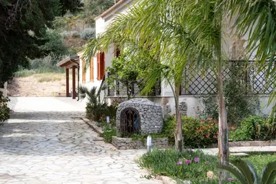a house with a stone pathway next to a building at Casa Laura di fronte la Tonnara in San Vito lo Capo