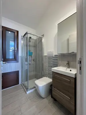 a bathroom with a shower and a toilet and a sink at Villa Futura in Scopello