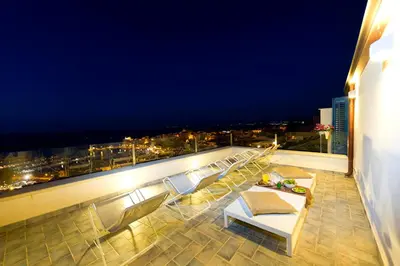 a balcony with a view of a city at night at Tannur B&B in Castellammare del Golfo