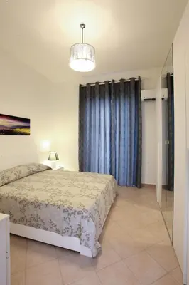 a bedroom with a bed and a blue curtain at Afrodite appartamento Ballarò in Palermo