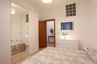 a white bedroom with a bed and a mirror at Afrodite appartamento Ballarò in Palermo