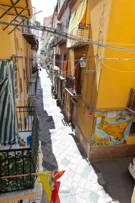a kitchen with a table and a kitchen with white cabinets at Afrodite appartamento Ballarò in Palermo