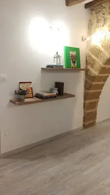 a room with two shelves on the wall with books at Cesare Home in Palermo