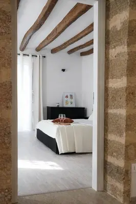 a bedroom with a bed in a white room at Cesare Home in Palermo