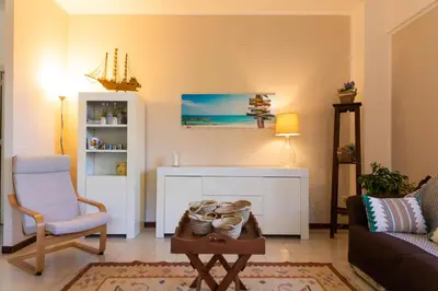 a living room with a couch and a chair and a table at Casa Pitea in Mondello