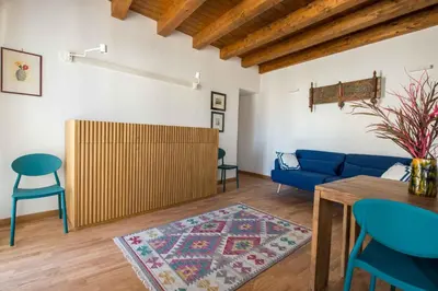 a kitchen and living room with blue walls and wooden ceilings at Cassaro Apartment con Terrazza by Wonderful Italy in Palermo