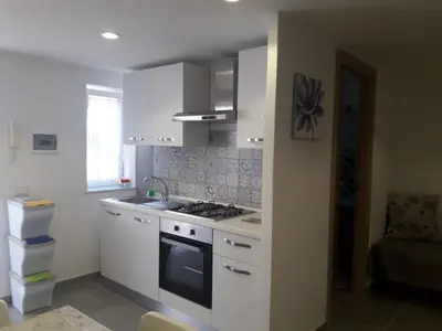 a kitchen with white cabinets and a stove top oven at VILLA MOGUNTIA in Ficarazzi