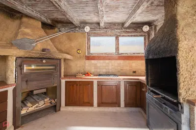 a kitchen with wooden cabinets and a stove top oven at Meravigliosa Villa a Trappeto vicino al mare in Trappeto