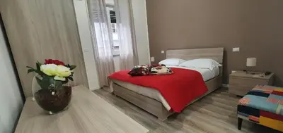 a bedroom with a bed and a vase of flowers at Carpe Diem Rooms by Marino Tourist in Palermo