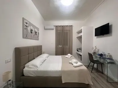 a bedroom with a bed and a desk in it at Carpe Diem Rooms by Marino Tourist in Palermo