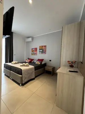 a bedroom with a bed and a couch in it at Solus b&b in Casteldaccia