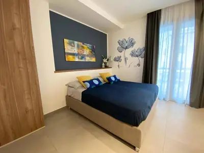 a bedroom with a bed with blue sheets and yellow pillows at Solus b&b in Casteldaccia