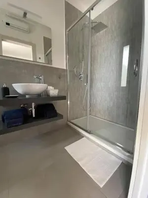 a bathroom with a glass shower and a sink at Solus b&b in Casteldaccia