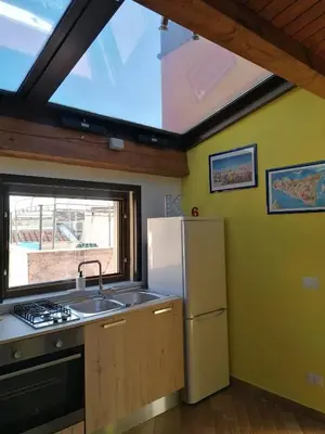 a kitchen with a sink and a refrigerator and a window at Appartamento Kardía in Palermo