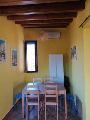 a dining room with a wooden table and chairs at Appartamento Kardía in Palermo