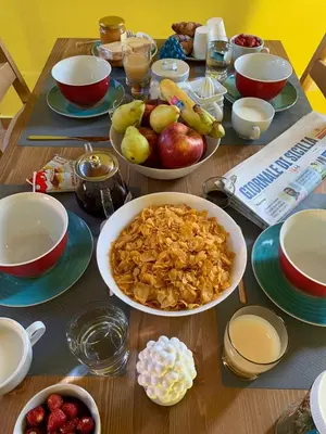 a wooden table topped with bowls of fruit and cereal at Appartamento Kardía in Palermo