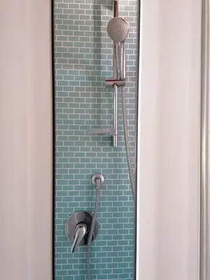 a shower in a bathroom with a blue brick wall at Appartamento Kardía in Palermo