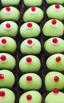 a bunch of green cupcakes with red dots on them at Appartamento Kardía in Palermo