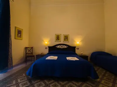 a bedroom with a blue bed with two towels on it at B&B Liberty in Palermo