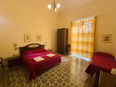 a bedroom with a red bed and a window at B&B Liberty in Palermo