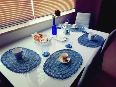 a white table with blue plates and cups and drinks at In Riva al Mare da Franca in Trabia
