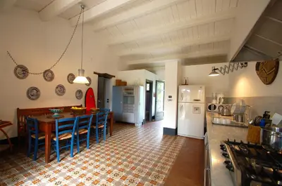 a kitchen with a table and chairs in a room at Villa con piscina vicino Cefalù (Sanificata) in Gratteri