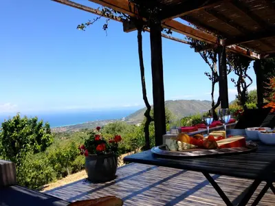 a table with a plate of food on top of a table at Villa con piscina vicino Cefalù (Sanificata) in Gratteri