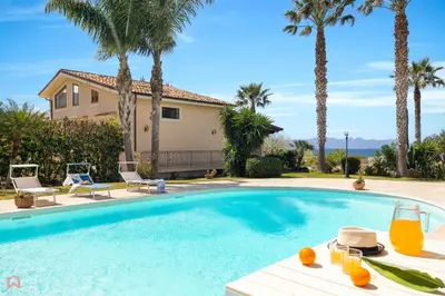 a swimming pool with a table with oranges on it at Panoramica Villa con Piscina sul Mare (Sanificata) in Cinisi