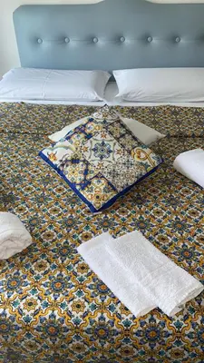 a bed with a blanket and pillows on it at Alba central City in Palermo