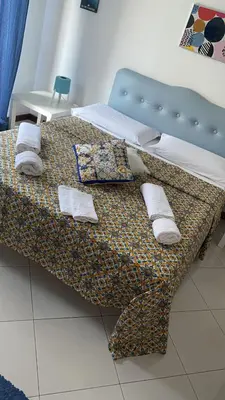 a bed with a blue headboard and pillows on it at Alba central City in Palermo