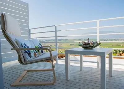 a chair and a table on a balcony with a view at Case Playa Resort Balestrate in Balestrate
