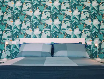 a bedroom with a bed with a floral wallpaper at Case Playa Resort Balestrate in Balestrate