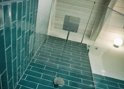 a blue tiled shower with a sign on the wall at Case Playa Resort Balestrate in Balestrate