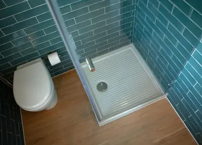 a bathroom with a toilet and a blue tiled wall at Case Playa Resort Balestrate in Balestrate