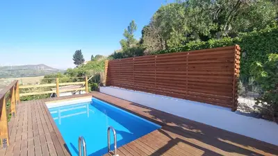 a swimming pool next to a wooden fence at villa Sun in Alcamo