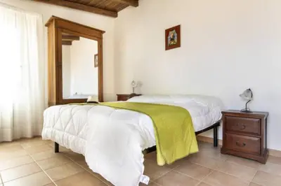 a bedroom with a bed with a green blanket on it at villa Sun in Alcamo