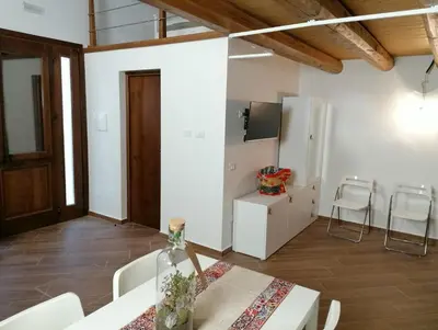 a dining room with a table and chairs and a television at Case Vacanze Azzurra, Loredana e Trinacria in Castellammare del Golfo