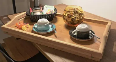 a wooden table with two cups and a basket of food at Meridiana B&B in Palermo