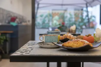 a table with a plate of food and a cup of coffee at Meridiana B&B in Palermo