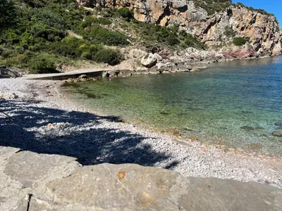 a beach with rocks and water and a mountain at Deliziosa Villa a 500 metri dal mare con Piscina in Terrasini