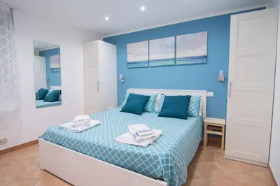 a blue bedroom with a bed with towels on it at Ncantu home in Palermo