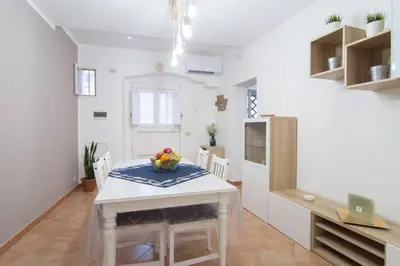 a kitchen and dining room with a white table and chairs at Ncantu home in Palermo