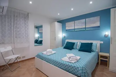 a blue bedroom with a bed with towels on it at Ncantu home in Palermo