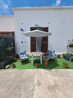 a patio with a table and two chairs and an umbrella at Bea's House in Castellammare del Golfo