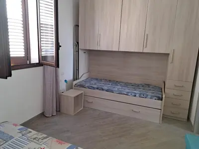 a small bedroom with a bed and a window at Bea's House in Castellammare del Golfo