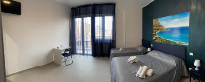a bedroom with two beds and a large window at Palermo City Room in Palermo
