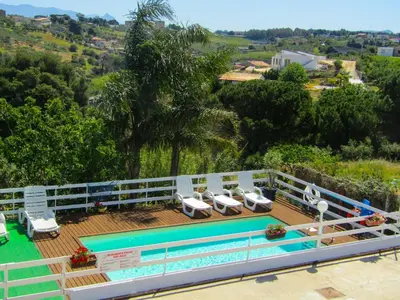 a deck with a pool and lounge chairs on it at Casa Contrada Molinello in Castellammare del Golfo