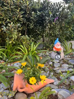 a garden with a statue and flowers on the rocks at Casa Contrada Molinello in Castellammare del Golfo