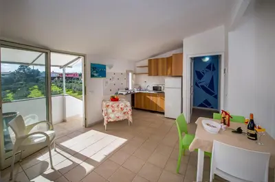 a kitchen with a table and a dining room at Casa Contrada Molinello in Castellammare del Golfo