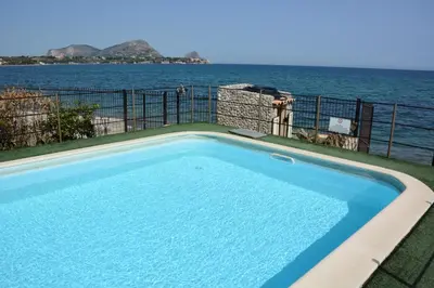 a swimming pool with the ocean in the background at Villa Silvia by Ville in Palermo in Casteldaccia